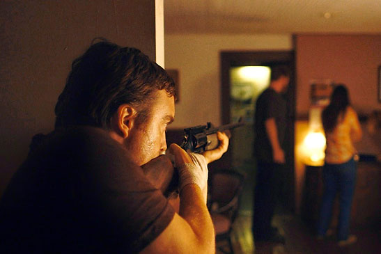 Macon Blair as Dwight takes aim at members of a family in the film 'Blue Ruin'