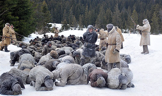 prison guards forcing prisoners to lie face down in the snow: a scene from The Way Back