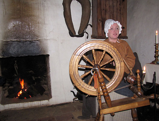 young woman demonstrating spinning at the Weaver's Cottage, Ulster American Folk Park, County Tyrone, Northern Ireland