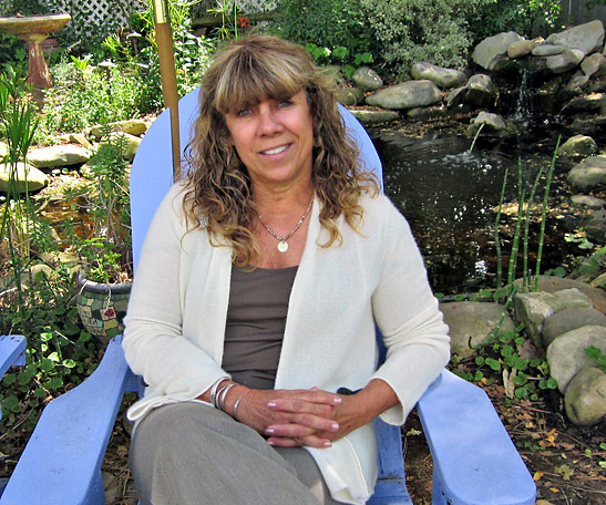 The Lavender Inn owner Kathy Hartley sitting at one of her lush gardens