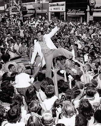 Pat Boone on top of a car at the Soapbox Derby in Akron, Ohio