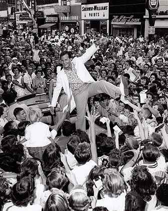 Pat Boone on top of a car at the Soapbox Derby in Akron, Ohio