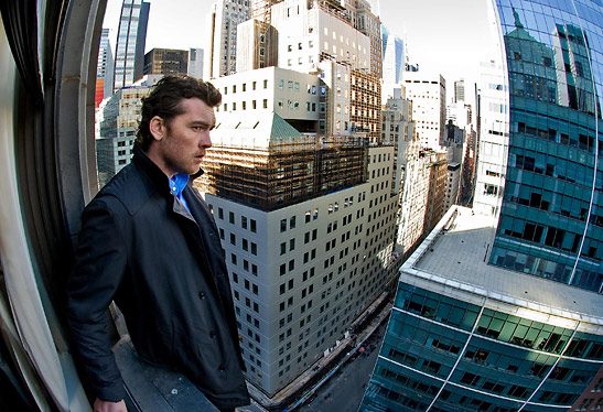 another photo of Sam Worthington on a building ledge
