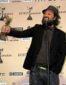 actor Thierry Guetta accepting the award for director Banksy for best documentary