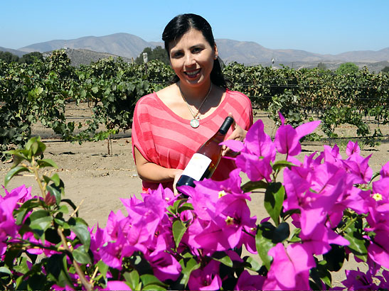 Monioca Palafox with a bottle of wine at her vineyard, Valle de Grulla