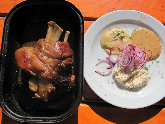 a typical lunch of pork leg with horseradish, onions and two types of mustard