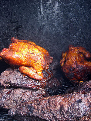 barbecued chicken and beef on a grill