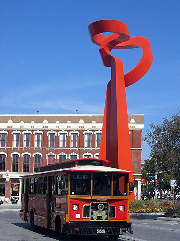 old bus with Torch of Friendship statue in the background, downtown San Antonio