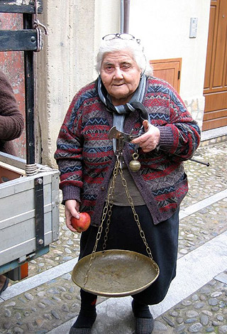 produce vender selling fruits in a southern Italian village alley