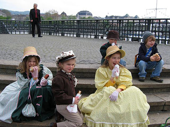 sitting children eating sausages cooked in the Boogg's ashes