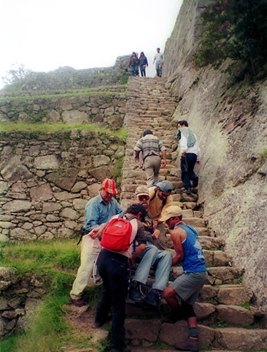 writer going up a flight of rock stairs on the way to Machu Picchu