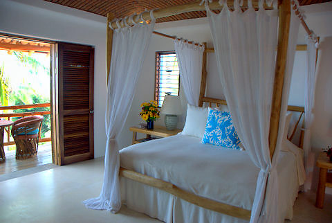 bedroom in a Las Alamandas villa featuring colorful Guatemalan pillows and Mexican fabrics
