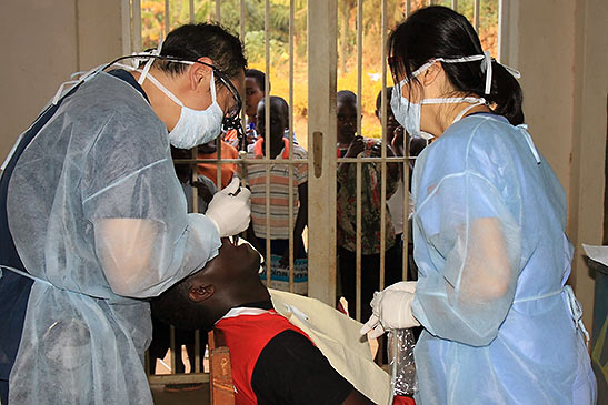Dr. Lee treating a Rwandan boy as others look on