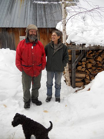 the Bowers with their dog Charlie in front of their saphouse, Kearsarge Gore Farm