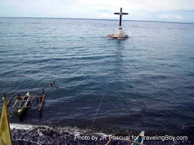 a cross marks the sunken cemetery of San Roque Church, Camiguin