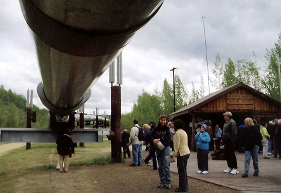 tourists stopping by to observe huge oil pipes of the Trans-Alaska Pipeline