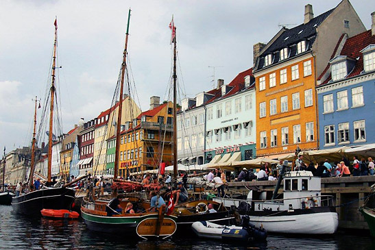 boats docked along the Kongens Nytorv with 17th century Dutch-style houses in the background