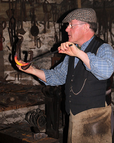 docent demonstrating metal crafting at the Ulster America Folk Park, Omaha, Northern Ireland