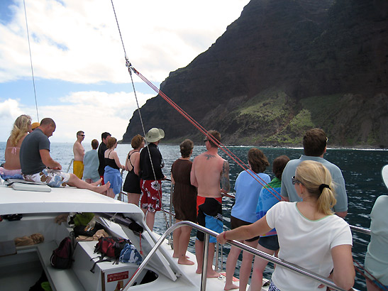 visitors on catamaran passing by Kaua'i coastline