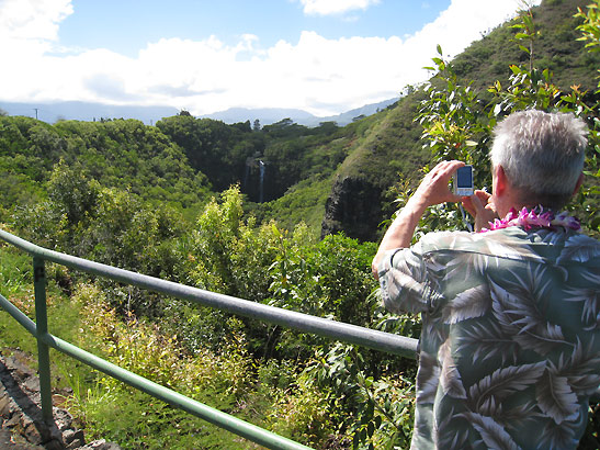 visitor on view deck taking a photo of waterfall