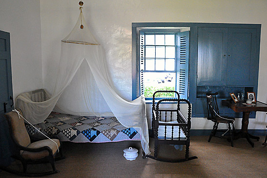 a bed with mosquito netting inside a room at the Baldwin House