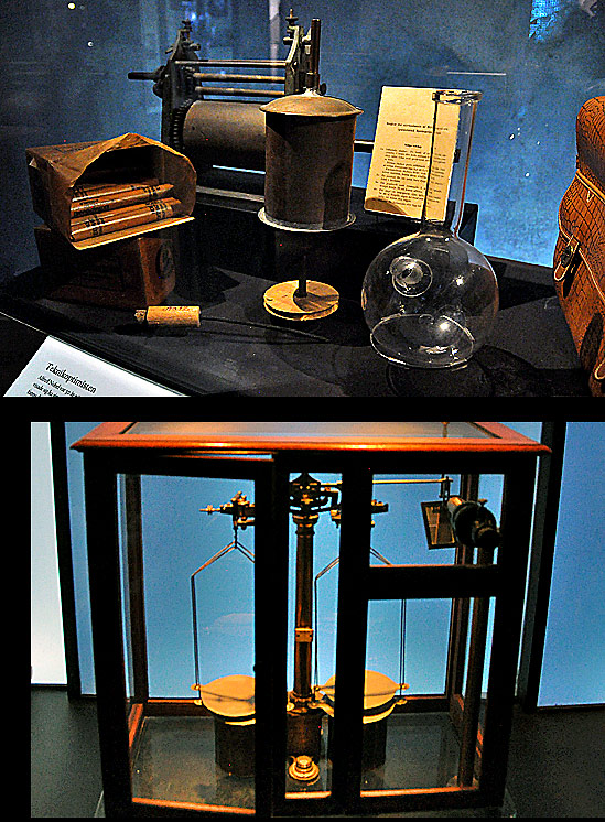 some of Alfed Nobel's personal effects including sticks of dynamite with Marie Curie's balanced weights below