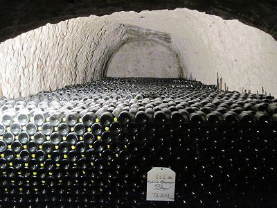a large pile of champagne bottles in a chalk cave, Taittengier vineyards, Champagne