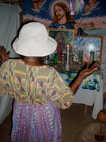 Garifuna healer praying at the alter in her temple