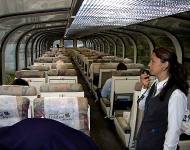 lady attendant aboard a Rocky Mountaineer train giving a commentary