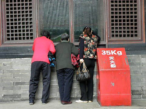 tourists looking into house wiindow at the Kong Family Mansion