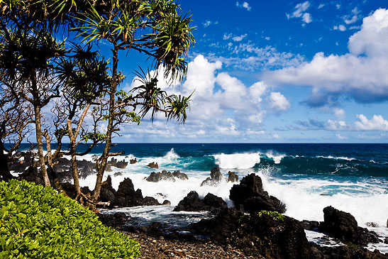 waves breaking on rocky, black sand beach