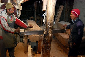 two men at work in a furniture factory supporting a READ library in the village of Tukche, Nepal