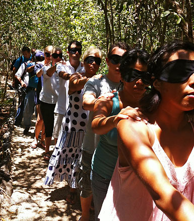 blindfolded tourists at the Hacienda Tres Rios Resort walking in line at the jungle