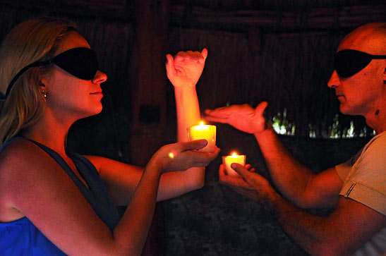 blindfolded guests with candles in their hands