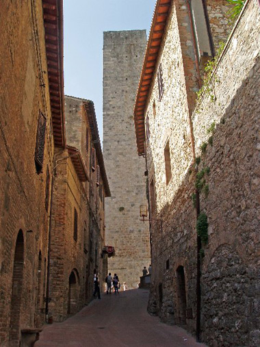 narrow street flanked by medieval buildings, a typical hill town in Tuscany