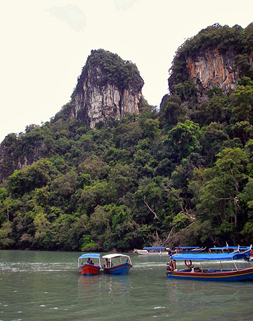 boats on a river with limestone cliffs in the background, Langkawi
