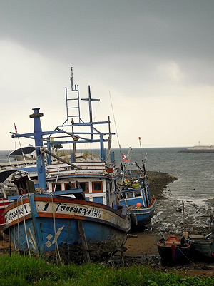 gathering storm at Baan Amphoe with fishing boats in the foreground