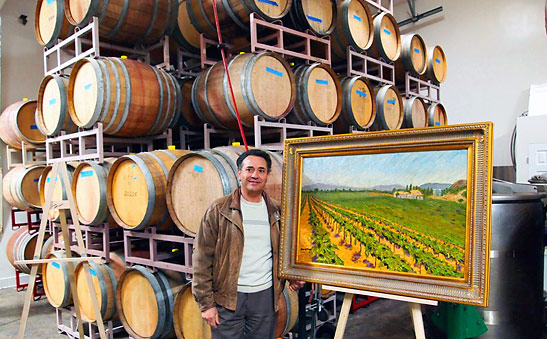 Robert Reyes with one of his paintings at his winery