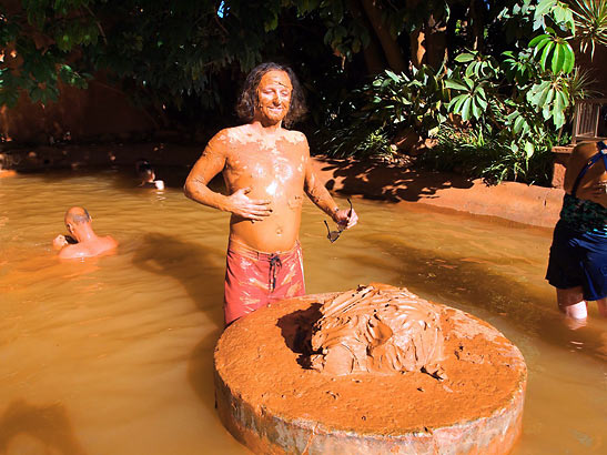 the writer covering his body in red clay mud at Club Mud