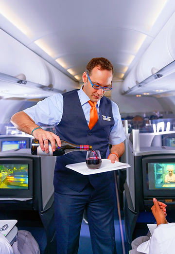 JetBlue steward serving drinks on JetBlue's Mint Class