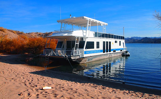 houseboat from Forever Houseboats docked on the shore of Lake Mohave