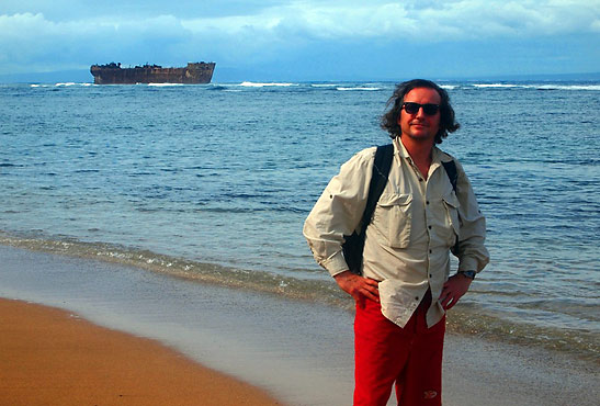 the writer at Shipwreck Beach with with a rusting WW2 oil tanker in the left background