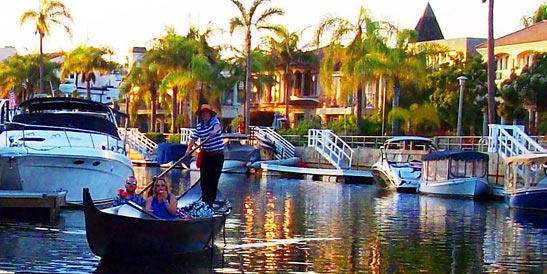 a gondola from the Gondola Getaway company cruising along a canal at Naples Island, Long Beach