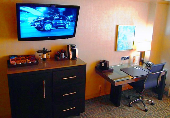 a room at the Luxe City Center Hotel showing 42 inch TV screen and computer desk