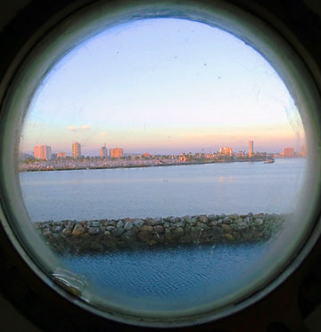 view of downtown Long Beach from a room porthole window at the Queen Mary