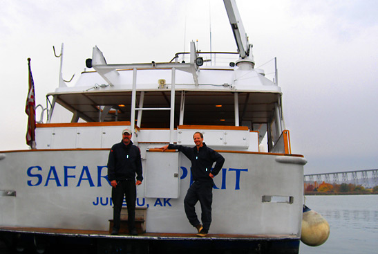 the captain and a crewman of the Safari Spirit in front of their yacht