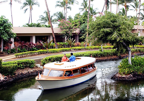 a boat takes guests to their rooms at the Hilton Waikoloa Village
