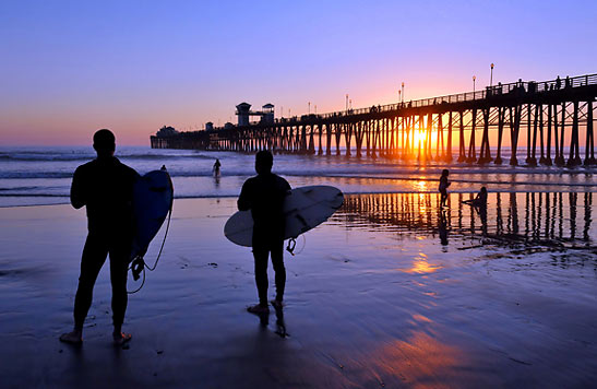 surfers near the Oceanside pier at sunset