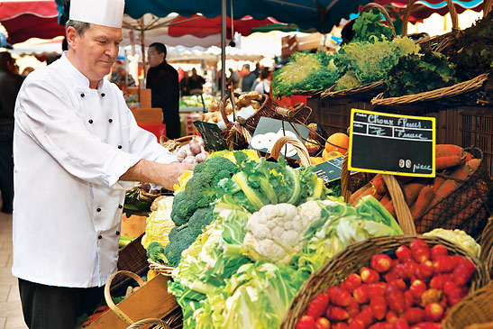 a Uniworld chef buying fresh produce at a market along the Rhone River