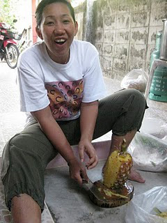 Thai woman chopping pineapple